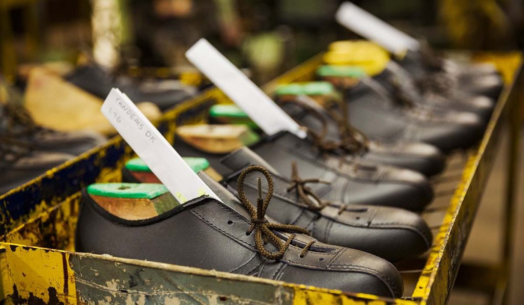 Deretan sepatu kulit sedang dirakit di pabrik sepatu modern sebagai bagian dari proses produksi