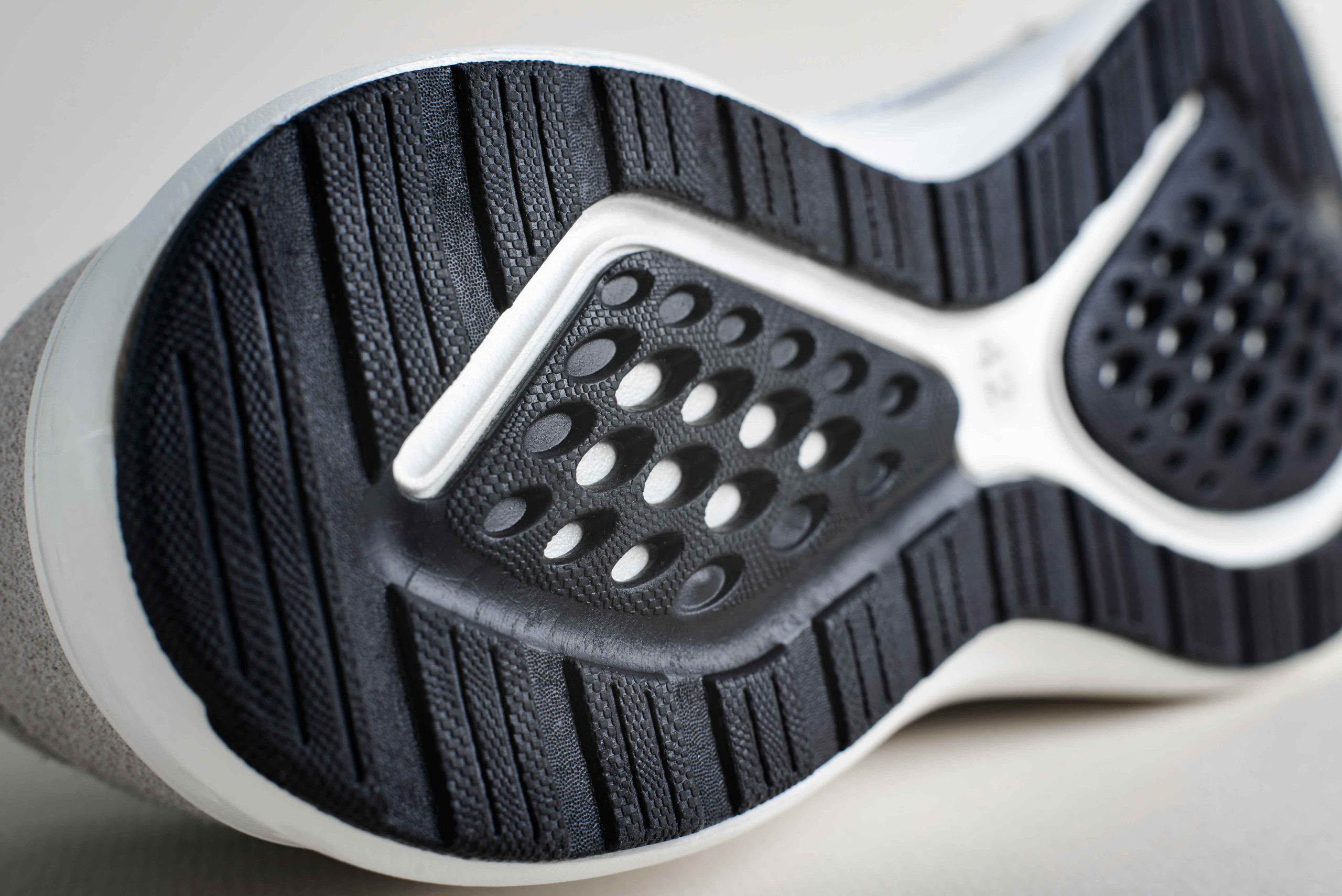 Outsole sepatu running dengan pola berlubang untuk sirkulasi udara dan fleksibilitas.